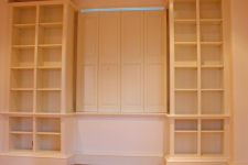 Fitted handpainted bookcase with decorative moulds and window shuttering